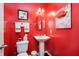 Vibrant powder room with red walls and decorative artwork and accessories adding a touch of personality at 4196 Parliament Way, Avon, IN 46123