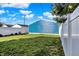 Backyard with white vinyl fencing, a well-maintained lawn, and a blue storage building at 424 N Randolph St, Indianapolis, IN 46201