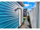 Side exterior view with blue siding, a white door and trim, leading to a well-maintained backyard at 424 N Randolph St, Indianapolis, IN 46201