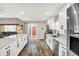 Bright kitchen with stainless steel appliances, white cabinetry, island, and wooden floors at 424 N Randolph St, Indianapolis, IN 46201