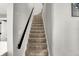 Carpeted stairs with a black handrail leading to the upper level of the home at 424 N Randolph St, Indianapolis, IN 46201