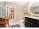 Well-lit bathroom featuring a granite countertop vanity, oval mirror, and adjacent toilet room at 4258 Hamilton Run, Zionsville, IN 46077