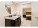 Chic bathroom with granite countertop vanity, a round mirror, and an adjacent bedroom at 4258 Hamilton Run, Zionsville, IN 46077