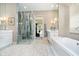 Bright bathroom features glass enclosed shower, white cabinets, decorative lighting and soaking tub at 4258 Hamilton Run, Zionsville, IN 46077
