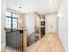 Bright upstairs hallway with hardwood floors, decorative lighting, and modern railings at 4258 Hamilton Run, Zionsville, IN 46077