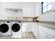Bright laundry room with modern appliances, stylish tile floors, and ample cabinet space at 4258 Hamilton Run, Zionsville, IN 46077