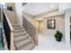 Elegant staircase featuring carpeted steps, black metal railings, and light wood trim, leading to the upper level at 4258 Hamilton Run, Zionsville, IN 46077