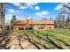 Expansive backyard featuring lush green grass, mature trees, and a charming brick home with a deck at 4263 W Fox Ridge Ave, Greenwood, IN 46143