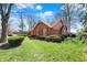 Classic brick house with a lush green lawn, neat shrubbery, and mature trees, set on an angle at 4263 W Fox Ridge Ave, Greenwood, IN 46143