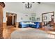 Bright living room with wood floors, a cozy blue sectional, and a view into the home's foyer at 4263 W Fox Ridge Ave, Greenwood, IN 46143