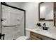 Bathroom featuring a tile-surround glass door shower, wood vanity, and modern sink at 4721 Ralston Ave, Indianapolis, IN 46205