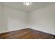 Vacant bedroom with hardwood flooring features white painted walls, modern light fixture, and electrical outlets at 4721 Ralston Ave, Indianapolis, IN 46205