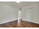 Bedroom with polished wood floors, white walls, double door closet, window, and open doorway to other rooms at 4721 Ralston Ave, Indianapolis, IN 46205