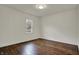 An empty bedroom with gleaming dark wood floors is illuminated by natural light coming in through the window at 4721 Ralston Ave, Indianapolis, IN 46205