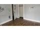 View of an empty bedroom with a closet, graffiti on the walls, and dark wood floors at 4925 E New York St, Indianapolis, IN 46201