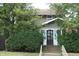 Charming home exterior with mature trees and greenery in the front yard at 4925 E New York St, Indianapolis, IN 46201