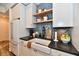 This kitchen features white cabinets, stone countertops, wood shelves, and a classic farmhouse sink at 504 N Park Ave # 3, Indianapolis, IN 46202