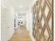 Hallway leading to a naturally lit living room, featuring a modern mirror at 5072 Astor Way, McCordsville, IN 46055