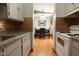 Galley kitchen with stainless steel sink and updated backsplash overlooking dining area at 535 Butterfly Cir, Greenwood, IN 46142