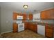 The kitchen features oak cabinets, laminate countertops, white appliances, and ample natural light at 5406 Shamus Dr, Indianapolis, IN 46235