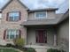 Close up of brick and vinyl siding with red front door and tasteful landscaping at 561 Prince Dr, Greenwood, IN 46142