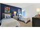 Cozy bedroom featuring two twin beds with gray headboards and a stylish blue accent wall at 5809 Sunstone Rd, Indianapolis, IN 46239