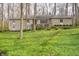 Stone-clad home with a low-pitched roof surrounded by lush, green ground cover and mature trees at 5918 Camelback Ct, Indianapolis, IN 46250