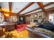 Cozy living room with wood-paneled walls, exposed beam ceiling, and stone fireplace featuring dark-leather furniture at 5918 Camelback Ct, Indianapolis, IN 46250