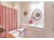 Well-lit bathroom featuring a vanity with sink, toilet, and a shower with red and white striped curtain at 633 Foxboro Dr, Avon, IN 46123