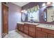 Bathroom with dual vanities, decorative mirrors, and a linen closet for ample storage at 633 Foxboro Dr, Avon, IN 46123