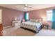 Bedroom with carpet, ceiling fan, a queen bed with patterned bedding, and a small vanity at 633 Foxboro Dr, Avon, IN 46123