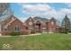 Beautiful red brick home featuring a manicured lawn, symmetrical design, and welcoming front entrance at 633 Foxboro Dr, Avon, IN 46123