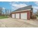 Spacious three-car garage with paved driveway, complemented by well-maintained landscaping and brick exterior at 633 Foxboro Dr, Avon, IN 46123