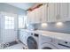 Well-lit laundry room featuring white cabinets, modern washer and dryer, and ample counter space at 633 Foxboro Dr, Avon, IN 46123
