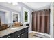 Bathroom with vanity, black cabinets, shower with curtain, and view to the exterior at 634 Dorman St, Indianapolis, IN 46202
