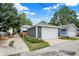 Detached two-car garage with white doors and adjacent landscaped yard nestled between neighboring houses and alley at 634 Dorman St, Indianapolis, IN 46202