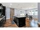 Modern kitchen featuring dark cabinets, a center island with granite countertops, and a sliding barn door to the pantry at 634 Dorman St, Indianapolis, IN 46202