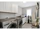 Laundry room with washer, dryer, white cabinets and countertops, and ironing board at 634 Dorman St, Indianapolis, IN 46202