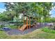 wooden playground featuring a slide, steps and play areas nestled in a shady, tree-filled backyard at 634 Dorman St, Indianapolis, IN 46202