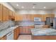 Spacious kitchen with stainless steel appliances, tile backsplash, and an island with granite countertops and wooden cabinets at 6997 Harbour Woods Overlook, Noblesville, IN 46062