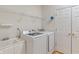 Bright laundry room featuring white washer and dryer, sink, and shelving for ample storage at 6997 Harbour Woods Overlook, Noblesville, IN 46062