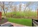 Backyard with chairs on a tiled patio, partial fence, and a larger lawn at 7208 Long Boat Dr, Indianapolis, IN 46250