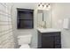 Cozy bathroom featuring a dark vanity, mirror, and matching built-in storage shelf at 7208 Long Boat Dr, Indianapolis, IN 46250