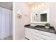 Well-lit bathroom features a vanity with black countertop and shower/tub combo at 7208 Long Boat Dr, Indianapolis, IN 46250