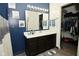 Charming bathroom features a dark vanity with bright lighting and decor, adjacent to a walk-in closet at 7527 Derek Dr, Camby, IN 46113