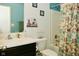 Bathroom with sink, toilet, shower, floral curtain, and decorative artwork at 7527 Derek Dr, Camby, IN 46113