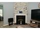 Close-up of a stone fireplace featuring a white mantel, a black hearth, and a built-in firebox at 7527 Derek Dr, Camby, IN 46113