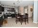 An open concept kitchen with dark cabinets, dining table, stainless steel appliances, and breakfast area at 7527 Derek Dr, Camby, IN 46113
