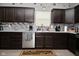 Kitchen with stainless steel appliances, dark cabinets, a tiled backsplash and modern flooring at 7527 Derek Dr, Camby, IN 46113