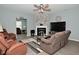 Living room featuring a ceiling fan, a stone fireplace, and comfortable furniture, including a large sofa at 7527 Derek Dr, Camby, IN 46113